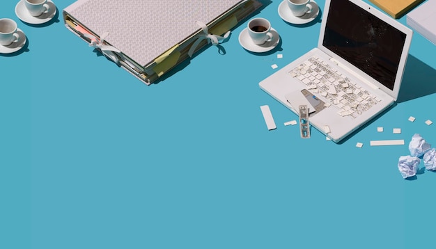 Tasses à café d'ordinateur portable brisées détruites et concept de surmenage et de frustration en papier froissé
