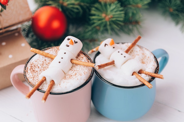 Tasses à chocolat chaud dans lesquelles les hommes de la guimauve se détendent. concept de couple