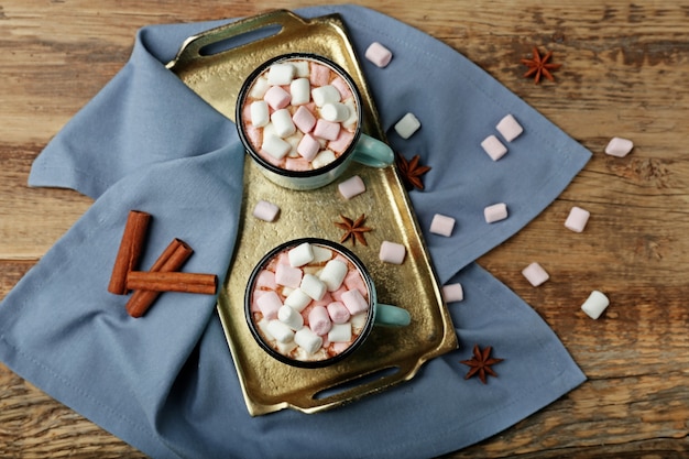 Tasses de chocolat chaud avec des guimauves sur plateau, gros plan