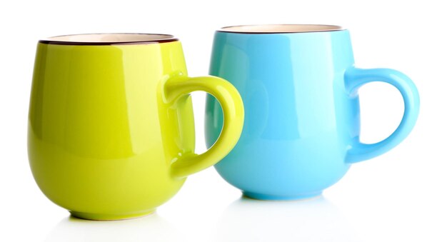 Photo des tasses colorées isolées sur du blanc