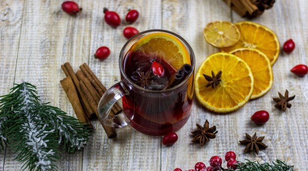 Tasses avec du vin chaud sur un fond en bois. Notion de nouvel an