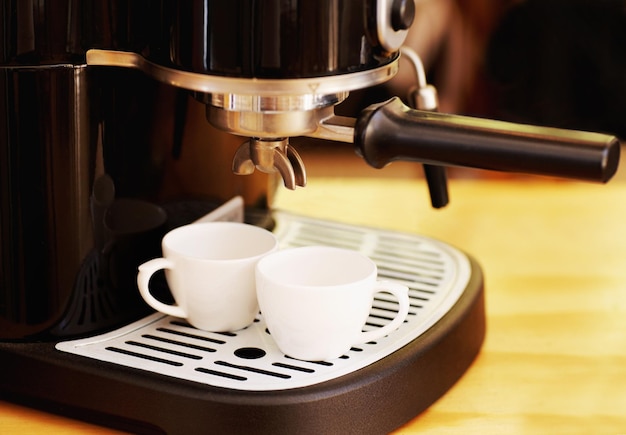 Tasses et machine à café sur table dans un café pour cappuccino latte ou boisson chaude Appareil électrique de restaurant et tasse de caféine pour faire ou préparer un expresso dans un magasin de détail ou une petite entreprise