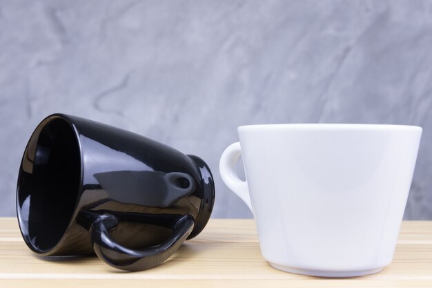 Tasses noires et blanches sur la table en bois