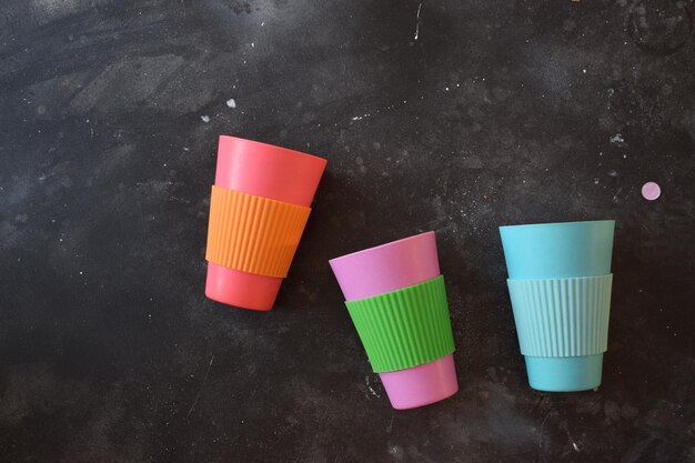 Photo des tasses en plastique colorées sur un fond noir