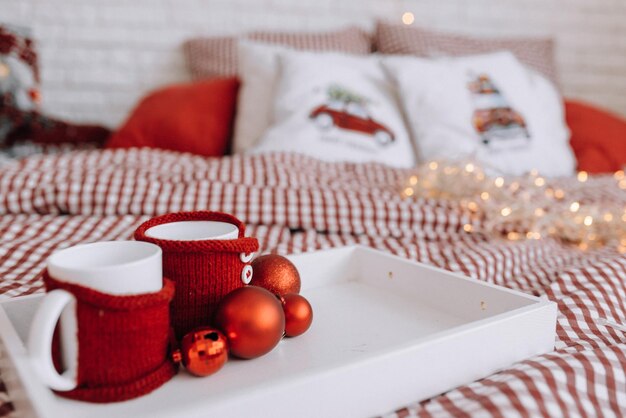 Tasses sur un plateau dans la chambre sur le lit Ambiance de Noël