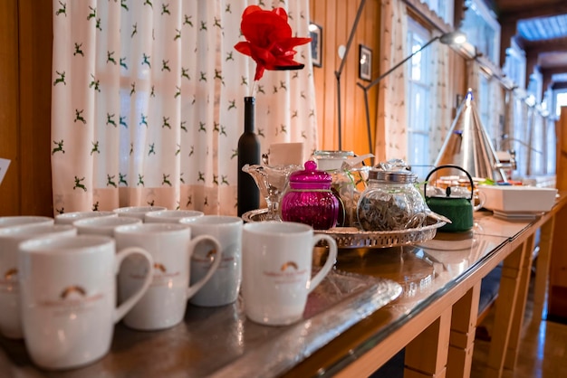 Tasses à thé et bocaux en verre assortis dans des plateaux sur le comptoir pour le petit-déjeuner au restaurant