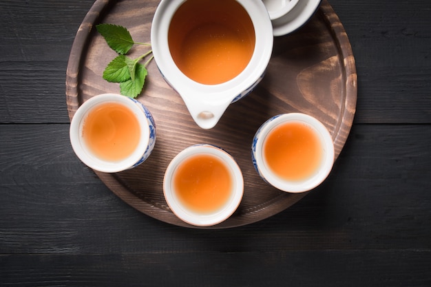 tasses de thé et bouilloire sur fond sombre