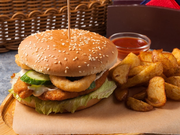 Tasty Burger avec filet de poulet avec tranches de pommes de terre et sauce tomate