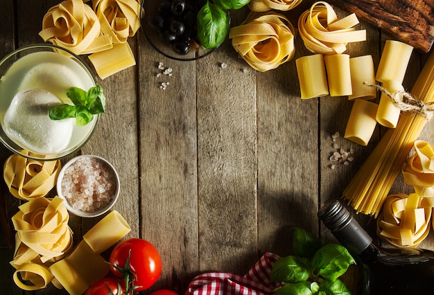 Tasty Colorful Fresh Italian Food Concept avec divers pâtes Spaghetti, Mozzarella au fromage, Basilic frais, Tomates, Huile d'Olive, Épices. Concept de cuisine. Lieu pour le texte.