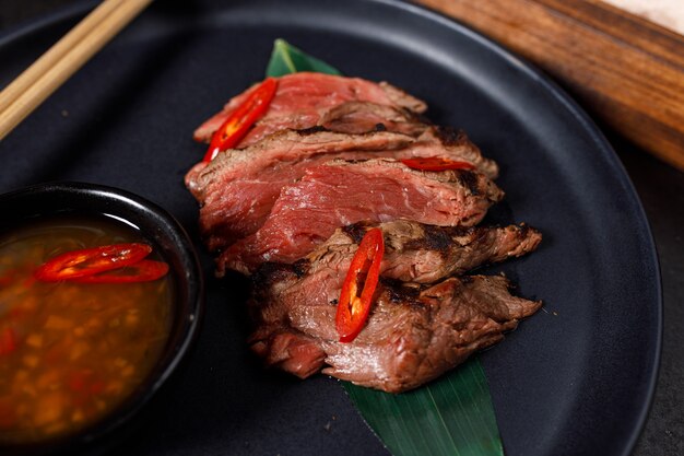 Tataki de boeuf servi sur sel chaud avec sauce