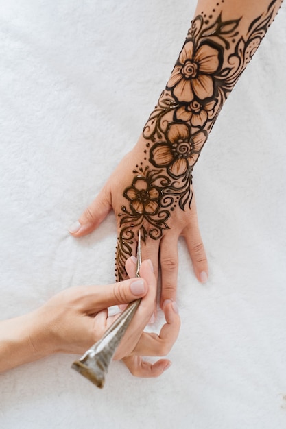 Tatouage au henné sur les mains d'une femme artiste dessin mehndi arabe