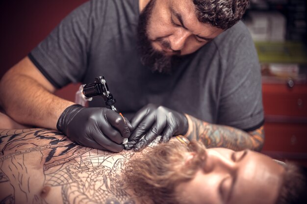 Le tatoueur fait des photos de tatouage dans un atelier.