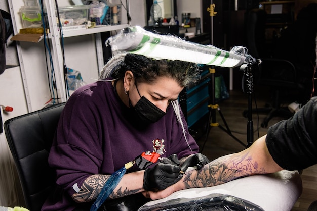 Photo un tatoueur fait un tatouage dans un salon