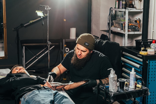 Un tatoueur fait un tatouage dans un salon