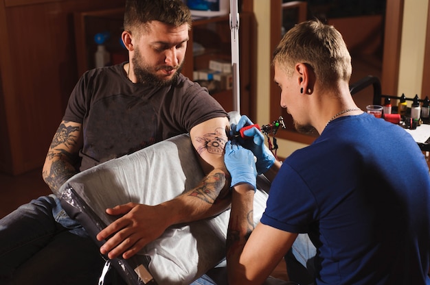 Tatoueur Fait Un Tatouage Sur La Main D'un Homme.