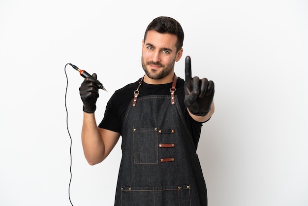 Tatoueur homme isolé sur fond blanc montrant et levant un doigt