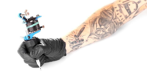Photo tatoueur main dans un gant noir avec machine à tatouer isolé sur fond blanc gros plan