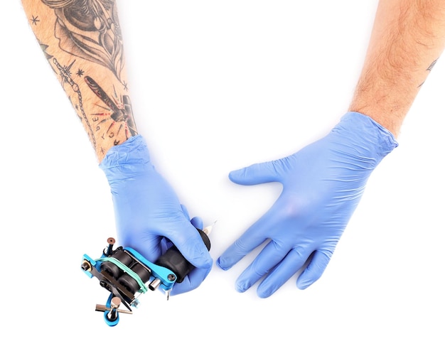 Photo tatoueur mains dans des gants bleus avec machine à tatouer isolé sur fond blanc gros plan