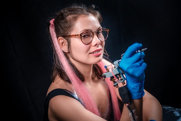 Tatoueur et un pistolet de tatouage dans un salon de tatouage