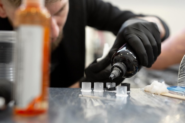 Le tatoueur prépare des outils et de l'encre avant de travailler dans un salon de tatouage