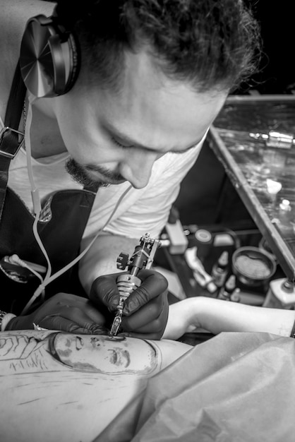 Un tatoueur professionnel démontre le processus d'obtention d'un tatouage dans un studio de tatouage