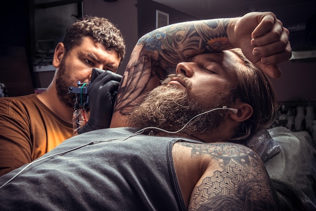 Photo un tatoueur professionnel fait un tatouage dans un studio de tatouage.