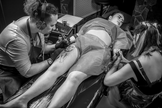 Un tatoueur professionnel montre le processus d'obtention d'un tatouage dans un studio de tatouage