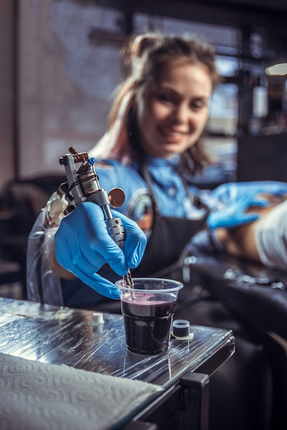 Tatoueur professionnel regardant la caméra dans un salon de tatouage