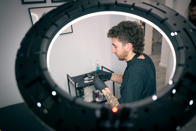 Un tatoueur professionnel tatoue un client dans un studio moderne