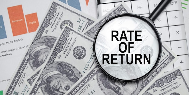 Taux de rendement mots sur une loupe avec des dollars et des graphiques