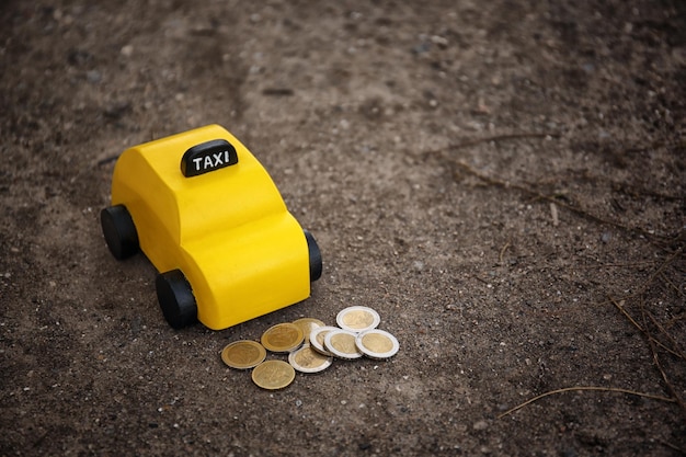 Taxi jouet jaune avec de l'argent au sol