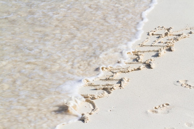 Été écrit sur la plage avec vague.