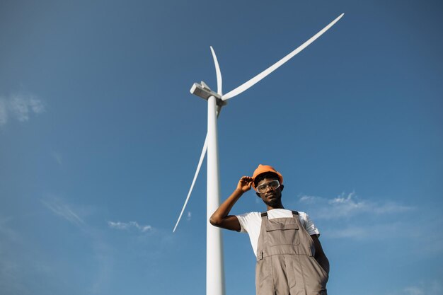 Technicien afro-américain posant sur un terrain avec des moulins à vent