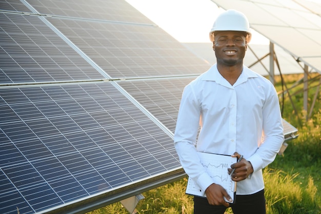 Un technicien afro-américain vérifie l'entretien des panneaux solaires. Un ingénieur noir à la centrale solaire.