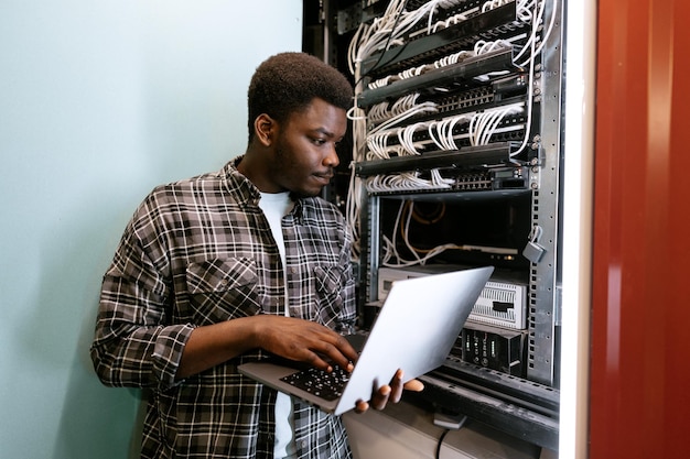 Technicien configurant les paramètres du serveur dans un centre de données pendant la journée