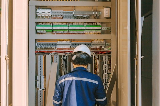 Technicien en contrôle sur le chantier vérifier le câblage sur l&#39;armoire de l&#39;automate