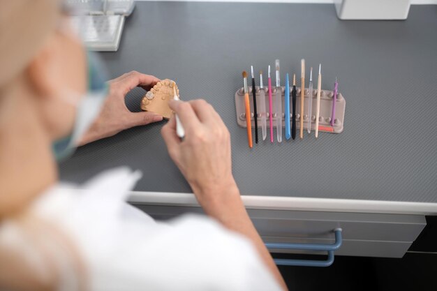 Technicien dentaire à l'aide de brosses pour nettoyer la prothèse en porcelaine