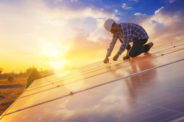 Le technicien en électricité et en instruments se détend tout en utilisant une clé pour entretenir le système électrique au champ de panneaux solaires