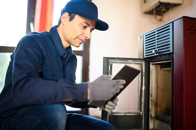 Technicien entretenant un appareil de chauffage de stockage à granulés