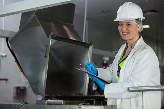 Technicien examinant la machine de transformation de la viande