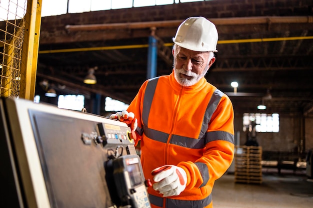 Technicien industriel opérant une machine de production en usine.