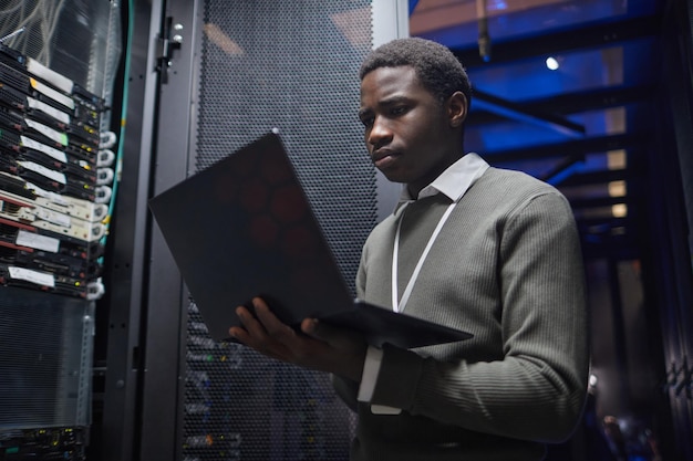 Technicien informatique afro-américain travaillant dans un centre de données