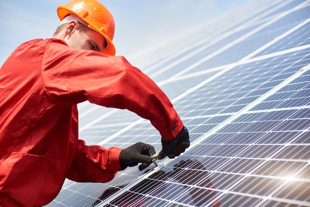 Le technicien installe la cellule solaire pour économiser l'énergie contre le ciel bleu