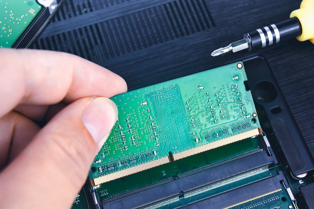 Un technicien installe une RAM dans un ordinateur portable (Random Access Memory)