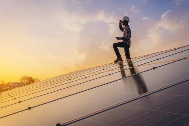 Technicien d'instruments électriques se détendre après la journée de travail fait l'entretien du système électrique au champ de panneaux solaires