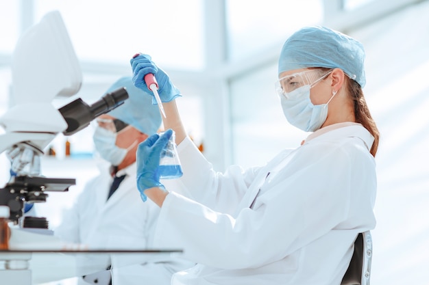 Technicien de laboratoire testant un liquide dans un ballon de laboratoire