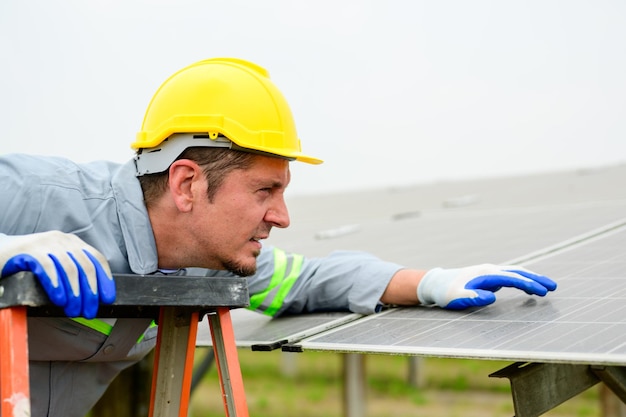 Technicien de maintenance vérifiant les panneaux solaires sur la ferme de cellules solaires