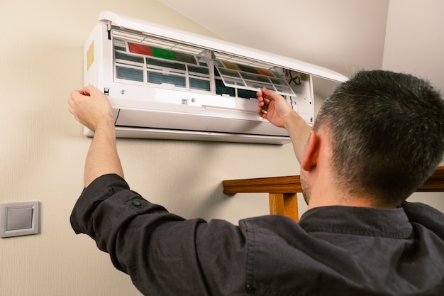 Technicien masculin nettoyage de climatiseur à l'intérieur