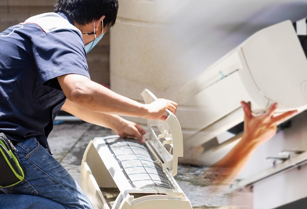 Technicien masculin nettoyant le climatiseur à l'intérieur Réparateur lavant les compartiments sales du climatiseur Concepts d'entretien et de réparation