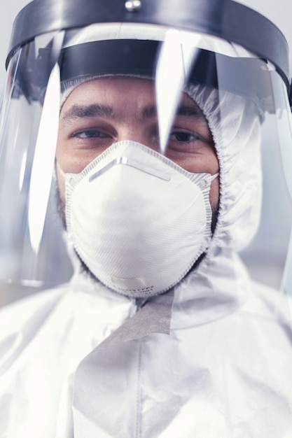 Technicien médical triste portant un uniforme ppe avec écran facial Chercheur surmené vêtu d'une combinaison de protection contre les invections avec le coronavirus pendant l'épidémie mondiale.